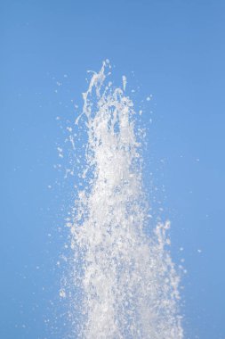 Mavi gökyüzüne karşı Su Çeşmesi sprey. Su sıçramaları odak dışında.