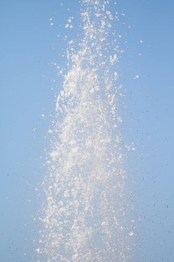Mavi gökyüzüne karşı Su Çeşmesi sprey. Su sıçramaları odak dışında.