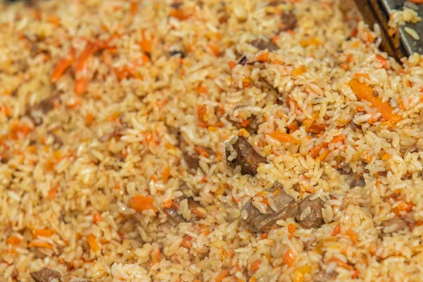 Pilaf meal, rice porridge with meat and vegetables, out of focus.