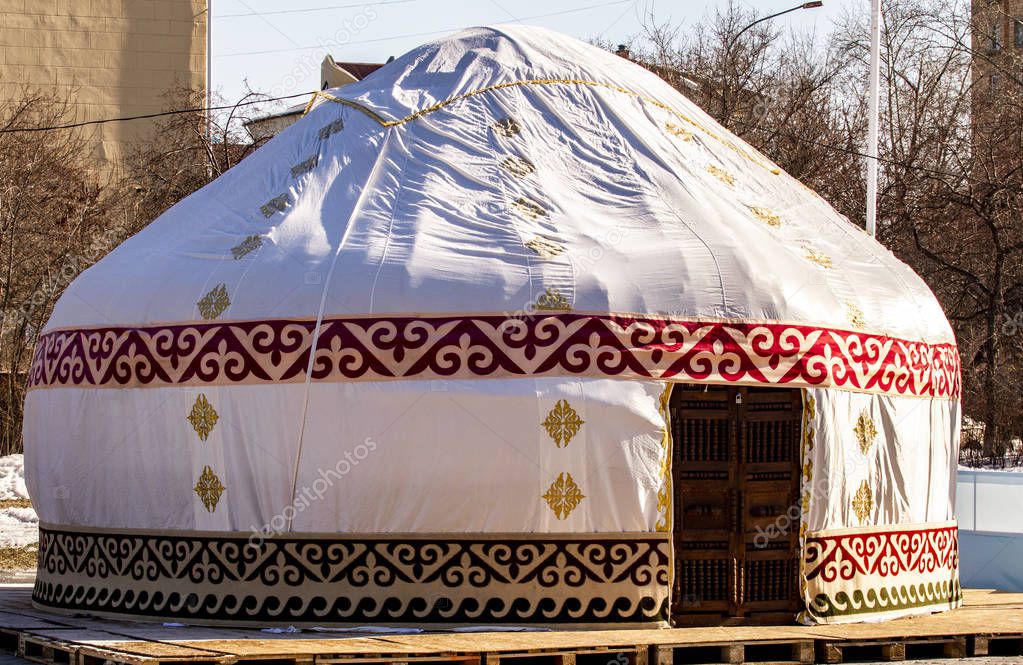 Round white yurt on the street. Dwelling of nomadic peoples of Central Asia.