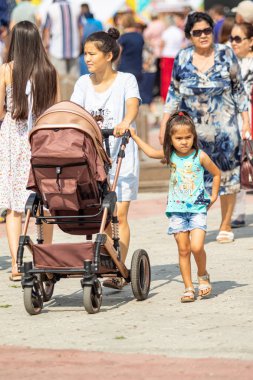 Petropavlovsk, Kazakistan - 17 Ağustos 2019: Çocukların aileleri şehrin sokaklarında ulusal kostümler içinde yürüyor. Gün tatili, binicilik sütü tatili, içki.