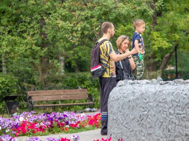 Petropavlovsk, Kazakistan - 23 Ağustos 2019: Baba anne ve oğlu yazın parkta yürüyor.