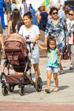 Petropavlovsk, Kazakistan - 17 Ağustos 2019: Çocukların aileleri şehrin sokaklarında ulusal kostümler içinde yürüyor. Gün tatili, binicilik sütü tatili, içki.