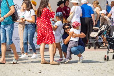 Petropavlovsk, Kazakistan - 17 Ağustos 2019: Çocukların aileleri şehrin sokaklarında ulusal kostümler içinde yürüyor. Gün tatili, binicilik sütü tatili, içki.