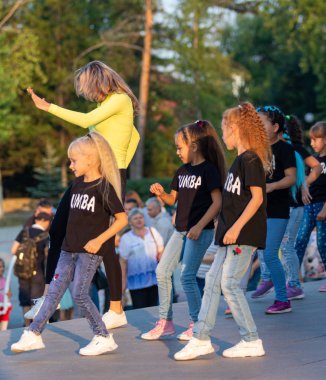 Petropavlovsk, Kazakistan - 23 Ağustos 2019: Çocuklar ve ebeveynler bir şehir parkında dans ediyor. Akşam yaz günü.