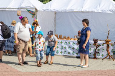 Petropavlovsk, Kazakistan - 17 Ağustos 2019: Çocukların aileleri şehrin sokaklarında ulusal kostümler içinde yürüyor. Gün tatili, binicilik sütü tatili, içki.