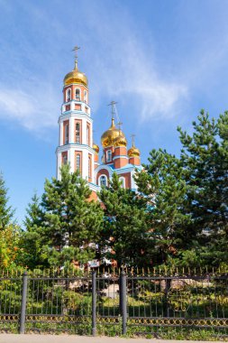 Petropavlovsk, Kazakistan - 20 Ağustos 2019: Gökyüzüne karşı altın kubbeli Ortodoks kilisesi. Doğa, yeşil ağaçlar, manzara.