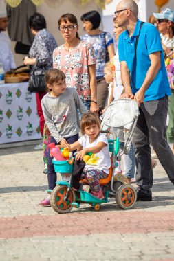 Petropavlovsk, Kazakistan - 17 Ağustos 2019: Çocukların aileleri şehrin sokaklarında ulusal kostümler içinde yürüyor. Gün tatili, binicilik sütü tatili, içki.