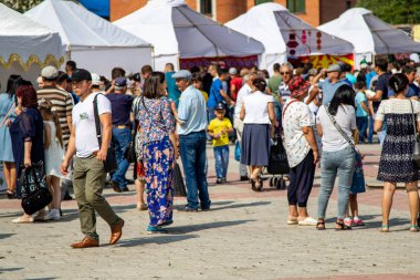 Petropavlovsk, Kazakistan - 17 Ağustos 2019: Çocukların aileleri şehrin sokaklarında ulusal kostümler içinde yürüyor. Gün tatili, binicilik sütü tatili, içki.