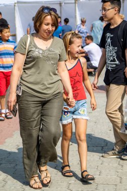 Petropavlovsk, Kazakistan - 17 Ağustos 2019: Çocukların aileleri şehrin sokaklarında ulusal kostümler içinde yürüyor. Gün tatili, binicilik sütü tatili, içki.