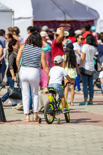 Petropavlovsk, Kazakistan - 17 Ağustos 2019: Çocukların aileleri şehrin sokaklarında ulusal kostümler içinde yürüyor. Gün tatili, binicilik sütü tatili, içki.