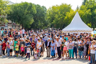 Petropavlovsk, Kazakistan - 17 Ağustos 2019: Çocukların aileleri şehrin sokaklarında ulusal kostümler içinde yürüyor. Gün tatili, binicilik sütü tatili, içki.