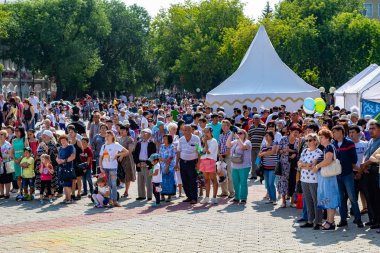 Petropavlovsk, Kazakistan - 17 Ağustos 2019: Çocukların aileleri şehrin sokaklarında ulusal kostümler içinde yürüyor. Gün tatili, binicilik sütü tatili, içki.