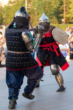 Petropavlovsk, Kazakistan - 23 Ağustos 2019: Ortaçağ şövalyesi savaşa, kostümlü karakterlerle yeniden inşaya ve zincir posta, kask kılıçları ve kalkanlarla ortaçağ zırhı için hazır.