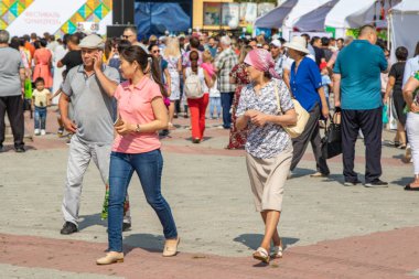 Petropavlovsk, Kazakistan - 17 Ağustos 2019: Çocukların aileleri şehrin sokaklarında ulusal kostümler içinde yürüyor. Gün tatili, binicilik sütü tatili, içki.