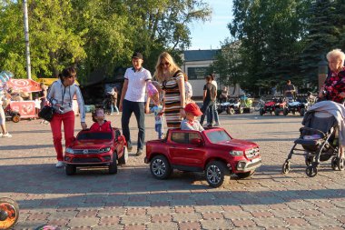 Petropavlovsk, Kazakistan - 24 Ağustos 2019: Şehirde çocuk parkı. Çocuklu ebeveynler yaz aylarında parkta yürürler. Küçükler için otomatik bisiklet.