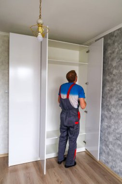 Petropavlovsk, Kazakistan - 22 Ağustos 2019: Bir adam bir dairede mobilya topluyor. Onarım işleri