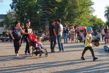 Petropavlovsk, Kazakistan - 24 Ağustos 2019: Şehirde çocuk parkı. Çocuklu ebeveynler yaz aylarında parkta yürürler. Küçükler için otomatik bisiklet.