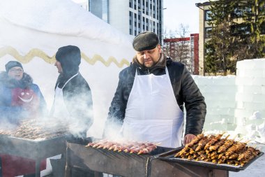 Petropavlovsk, Kazakistan - 10 Mart 2019: Erkekler sokakta kış barbeküsünü kızartıyor.