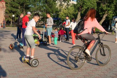Petropavlovsk, Kazakistan - 24 Ağustos 2019: Şehirde çocuk parkı. Çocuklu ebeveynler yaz aylarında parkta yürürler. Küçükler için otomatik bisiklet.