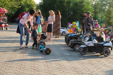 Petropavlovsk, Kazakistan - 24 Ağustos 2019: Şehirde çocuk parkı. Çocuklu ebeveynler yaz aylarında parkta yürürler. Küçükler için otomatik bisiklet.