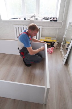 Petropavlovsk, Kazakistan - 22 Ağustos 2019: Bir adam bir dairede mobilya topluyor. Onarım işleri