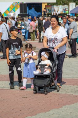 Petropavlovsk, Kazakistan - 17 Ağustos 2019: Çocukların aileleri şehrin sokaklarında ulusal kostümler içinde yürüyor. Gün tatili, binicilik sütü tatili, içki.