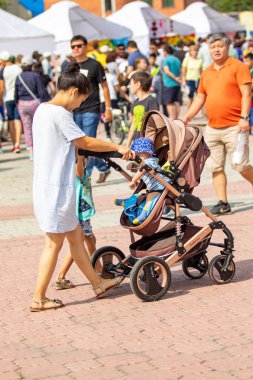 Petropavlovsk, Kazakistan - 17 Ağustos 2019: Çocukların aileleri şehrin sokaklarında ulusal kostümler içinde yürüyor. Gün tatili, binicilik sütü tatili, içki.