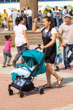 Petropavlovsk, Kazakistan - 17 Ağustos 2019: Çocukların aileleri şehrin sokaklarında ulusal kostümler içinde yürüyor. Gün tatili, binicilik sütü tatili, içki.