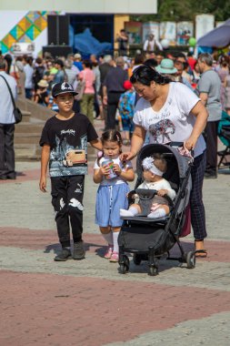 Petropavlovsk, Kazakistan - 17 Ağustos 2019: Çocukların aileleri şehrin sokaklarında ulusal kostümler içinde yürüyor. Gün tatili, binicilik sütü tatili, içki.