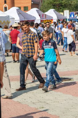 Petropavlovsk, Kazakistan - 17 Ağustos 2019: Çocukların aileleri şehrin sokaklarında ulusal kostümler içinde yürüyor. Gün tatili, binicilik sütü tatili, içki.