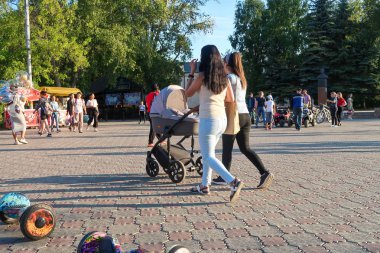 Petropavlovsk, Kazakistan - 24 Ağustos 2019: Şehirde çocuk parkı. Çocuklu ebeveynler yaz aylarında parkta yürürler. Küçükler için otomatik bisiklet.