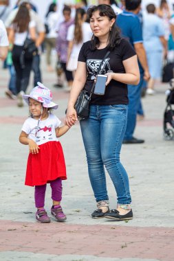 Petropavlovsk, Kazakistan - 17 Ağustos 2019: Çocukların aileleri şehrin sokaklarında ulusal kostümler içinde yürüyor. Gün tatili, binicilik sütü tatili, içki.