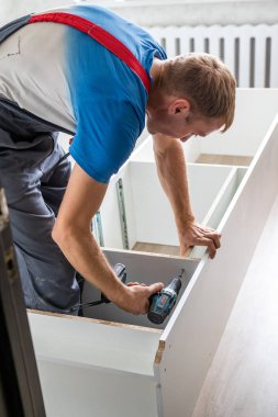 Petropavlovsk, Kazakistan - 22 Ağustos 2019: Bir adam bir dairede mobilya topluyor. Onarım işleri