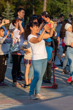 Petropavlovsk, Kazakistan - 23 Ağustos 2019: Anne babalar gece leri şehir parkında yürüyor. Gençler toplu şenlikler geçiriyor.