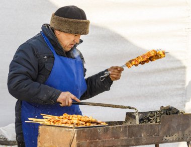 Petropavlovsk, Kazakistan - 10 Mart 2019: Erkekler sokakta kış barbeküsünü kızartıyor.