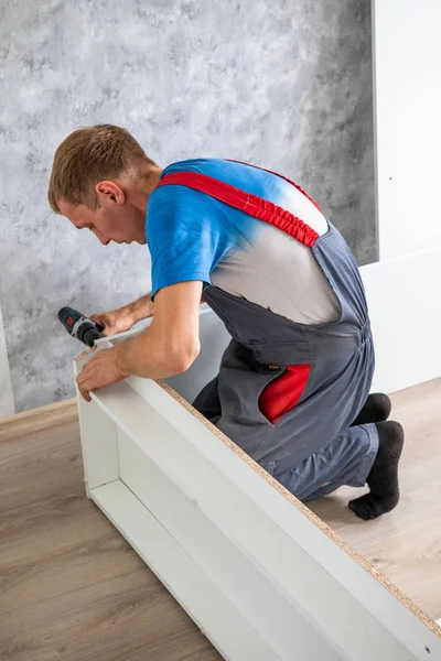 Petropavlovsk, Kazakistan - 22 Ağustos 2019: Bir adam bir dairede mobilya topluyor. Onarım işleri