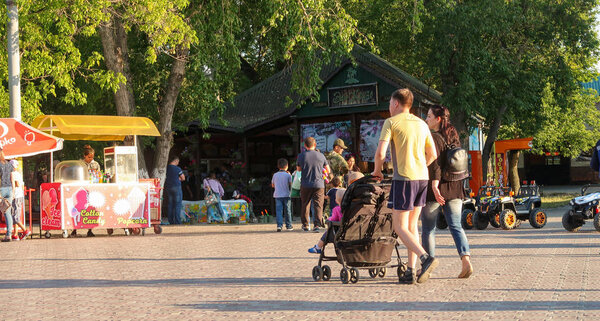 Petropavlovsk, Kazakhstan - August 24, 2019: Children's park in the city. Parents with children walk in the summer in the park. Auto bikes for the little ones.