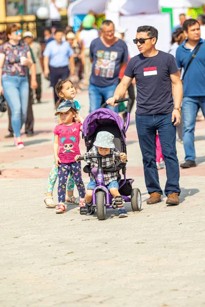 Petropavlovsk, Kazakistan - 17 Ağustos 2019: Çocukların aileleri şehrin sokaklarında ulusal kostümler içinde yürüyor. Gün tatili, binicilik sütü tatili, içki.