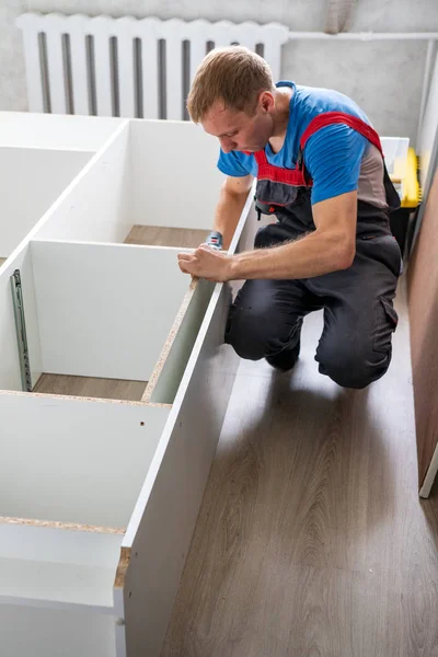 Petropavlovsk, Kazakistan - 22 Ağustos 2019: Bir adam bir dairede mobilya topluyor. Onarım işleri