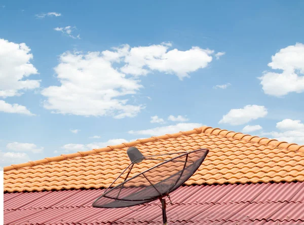 antenna on the roof of the house, the sky clouds