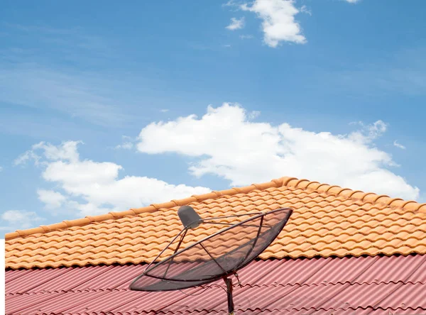 antenna on the roof of the house, the sky clouds