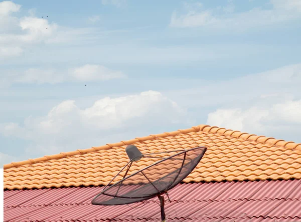 antenna on the roof of the house, the sky clouds