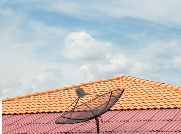 antenna on the roof of the house, the sky clouds