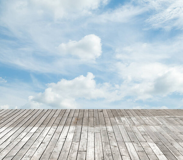 Wooden floor against the sky with clouds