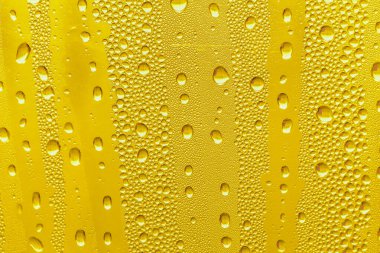 Cam su damlaları, sarı arka plan bira, buğulu arka plan.