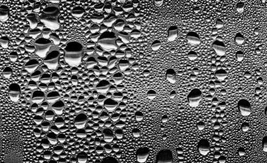 Cam üzerinde yağmur damlaları, siyah-beyaz arka plan, moda cam doku.