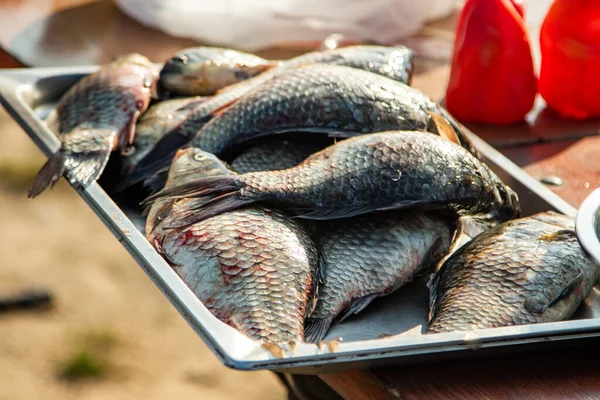 On the table, clean the fish from the scales and remove the entrails. Peeling and fillet of fresh fish that use a knife to clean the fish. Seafood cooking.