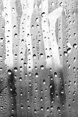Cam üzerinde yağmur damlaları, siyah-beyaz arka plan, moda cam doku.