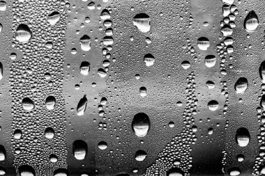 Cam üzerinde yağmur damlaları, siyah-beyaz arka plan, moda cam doku.